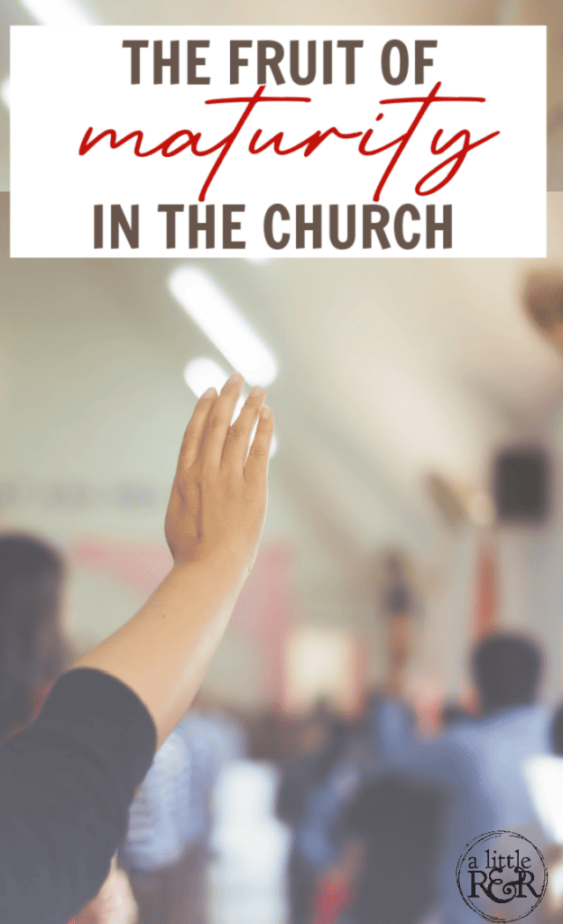 Person in black shirt raising hand in church