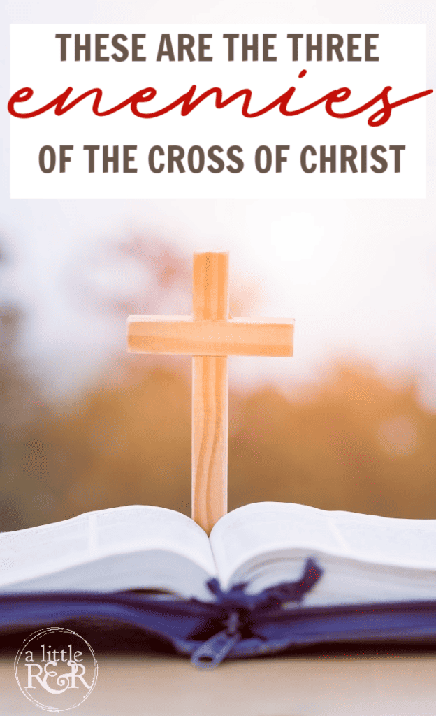 Bible sitting on table with a cross in the background