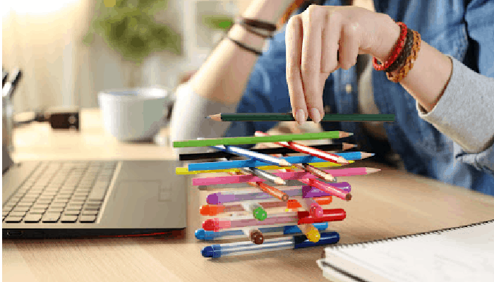 Person distracting themselves with stacking pens