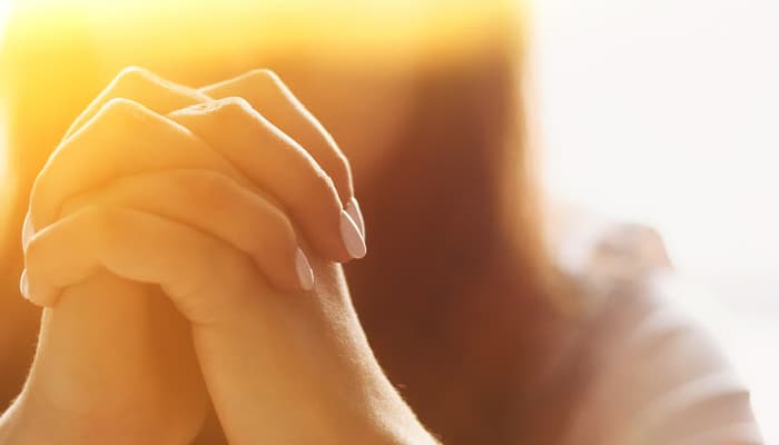 person praying with hands folded