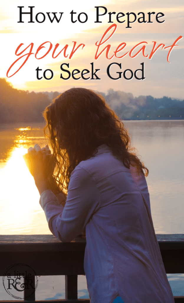 Woman on balcony looking over a lake with hands folded in prayer