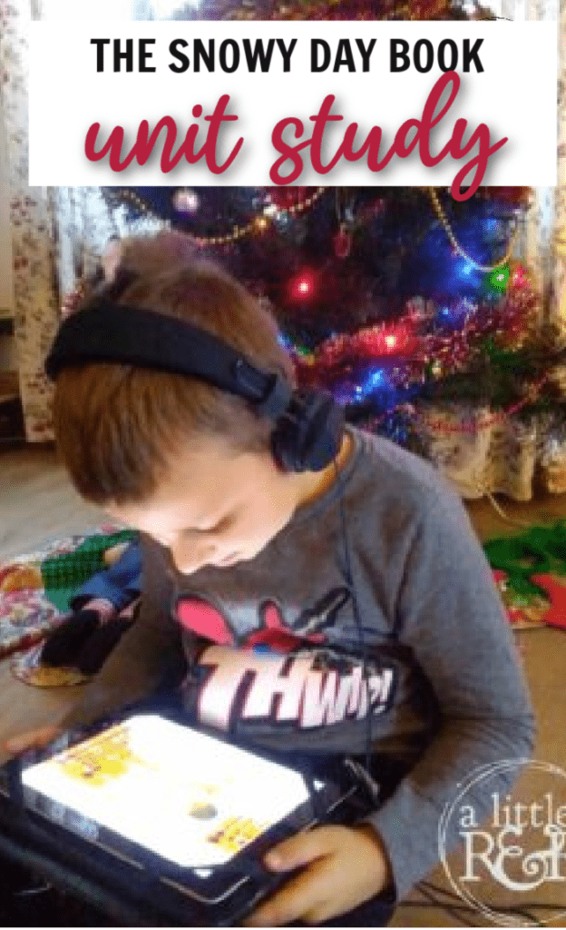 boy sitting in front of a Christmas tree and watching a reading of The Snowy Day book on YouTube