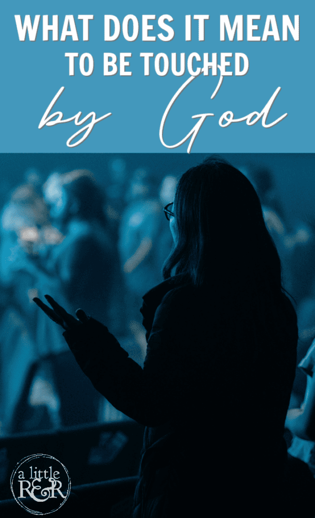 woman in auditorium raising hands in worship