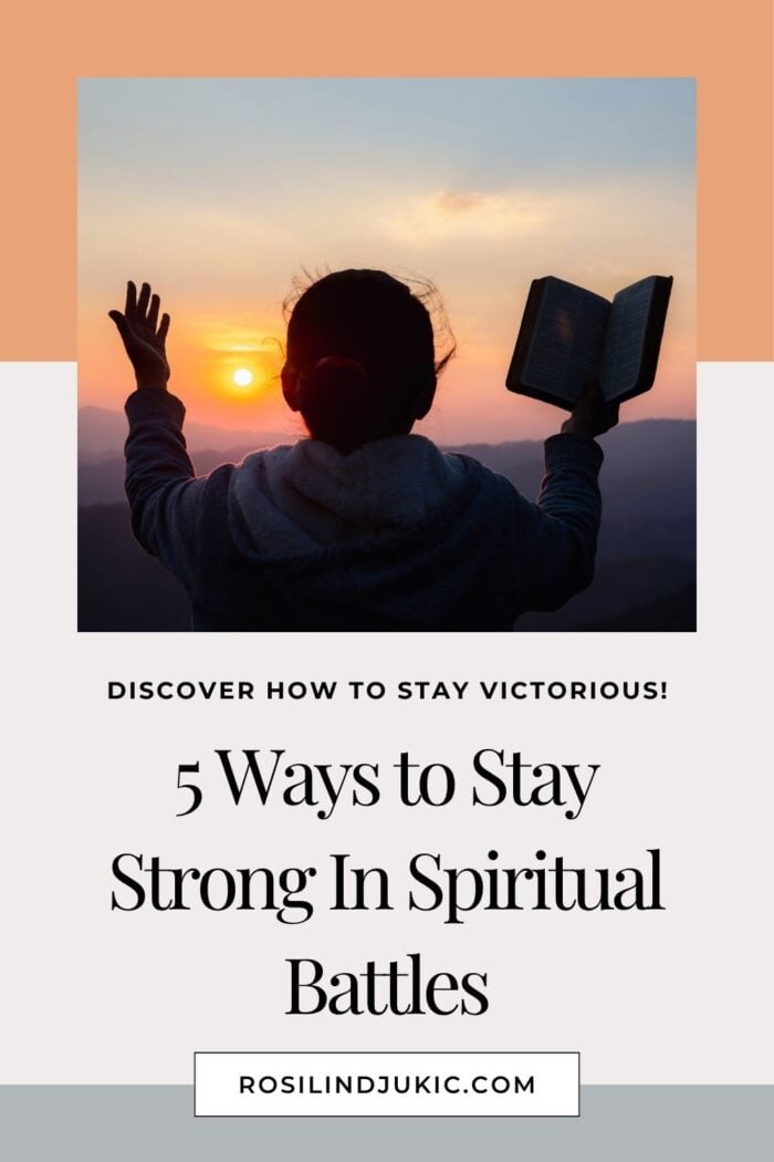 Woman with raised hands and holding a Bible